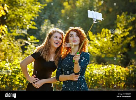 Two Young Pretty Girls Make Selfie Girls Smile And Laugh Self Portrait Shooting On The Phone