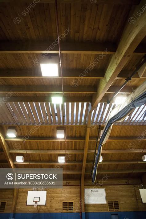 Basketball Hoop And Arched Ceiling In Gymnasium Superstock