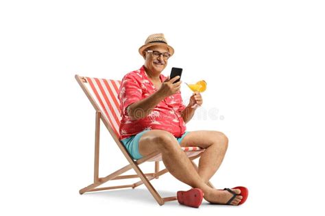 Mature Male Tourist Sitting In A Chair Holding A Cocktail And A