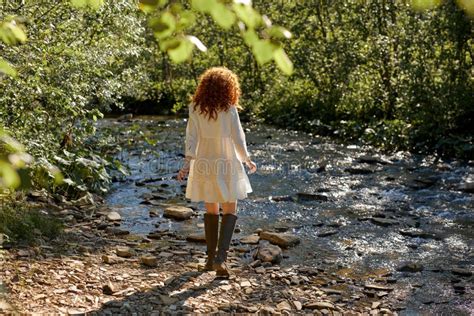 Rear View On Curly Redhead Lady Having Rest On River Walking Alone