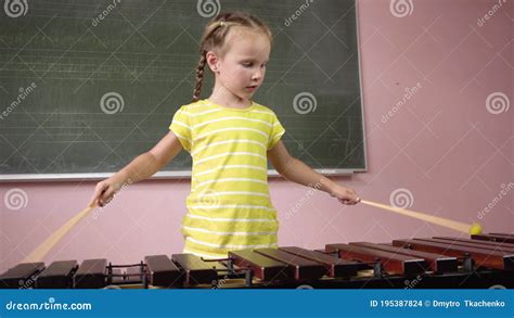 The Child Learns To Play The Xylophone A Little Girl Plays The