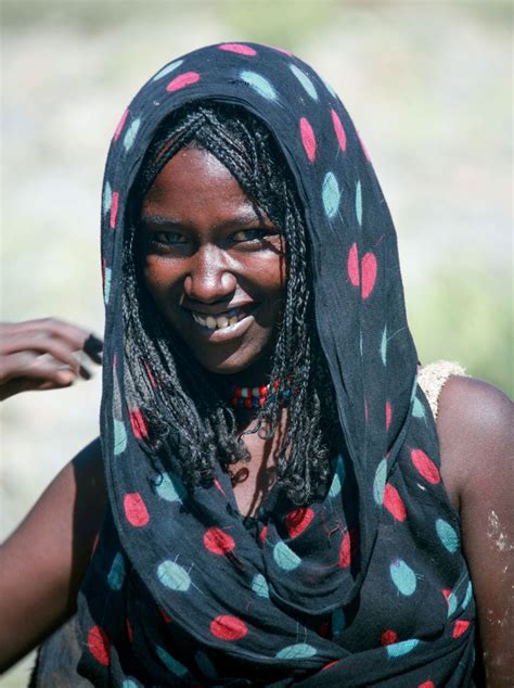 A Woman Wearing A Black And Red Polka Dot Shawl Smiles At The Camera