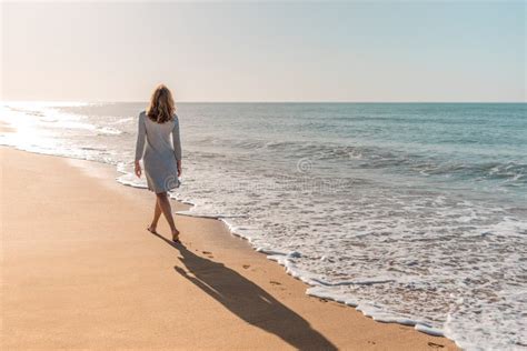 Woman Walking Along The Beach Looking At The Sun Stock Image Image Of