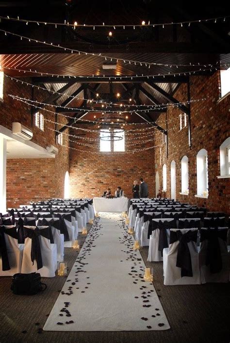 Designed as a blank canvas, this is the perfect backdrop for any wedding design. Wedding venue. White aisle with vases & candles and rose ...