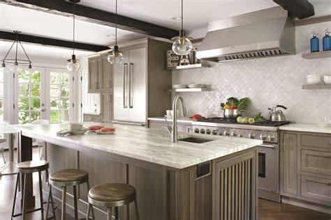 This traditional style kitchen uses earth tones like this custom green cabinets and gray green backsplash which helps bring kitchen cabinets to fall in love with | plain & fancy cabinetry. 3 Inspiring Kitchens | Traditional Home