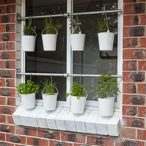 Several Potted Plants Are Hanging On The Window Sill In Front Of A