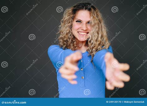Smiling Girl Stretches Her Hands Forward On A Plain Background Stock