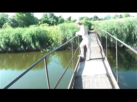 Summer Nostalgia Dressed In Sun Sexy Naked Woman MILF Walks On Hanging Bridge Of River
