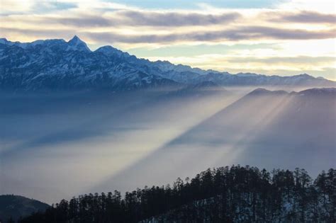 Premium Photo Sun Rays Falling In The Fog From Behind Mountain