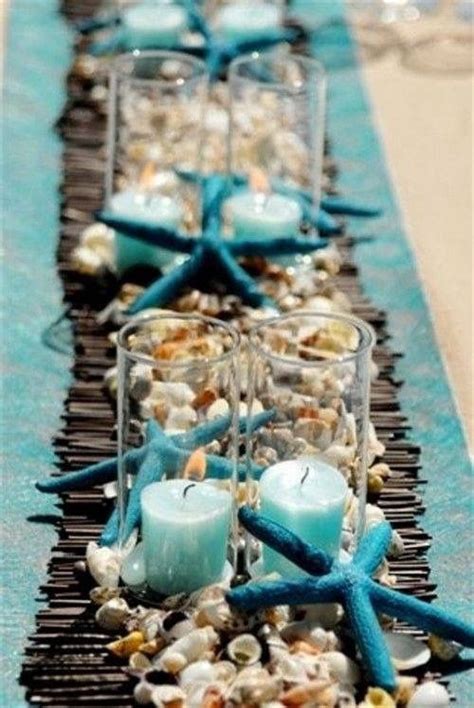 the table is decorated with candles and seashells