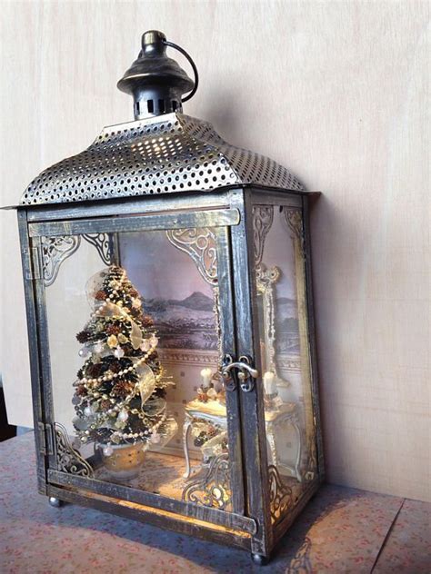 Metallic Lantern House Inside A Christmas Scene With Tree In Shades Of