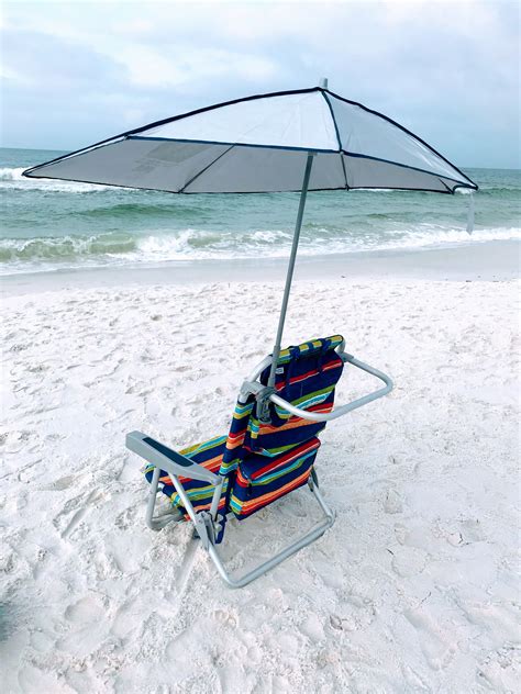 A Beach Chair With An Umbrella On The Sand
