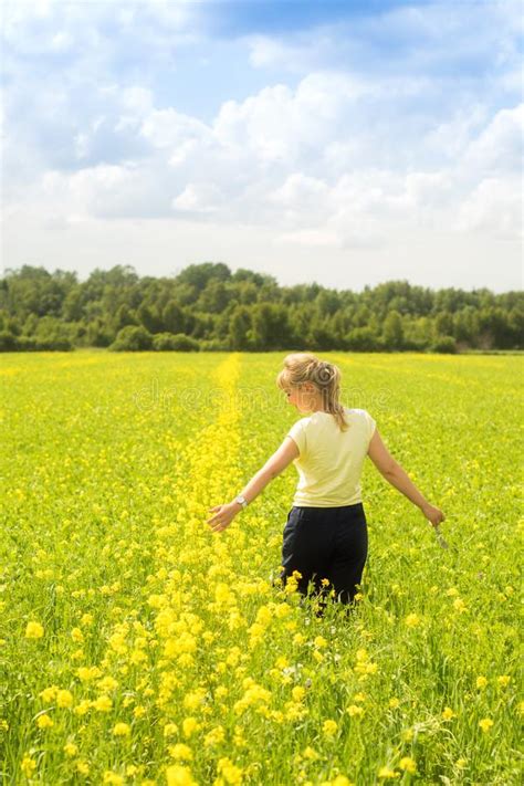 Happy Young Woman Enjoying Summer And Nature In Yellow Flower Field