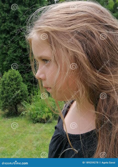 Young Thinking Girl In Garden Standing And Waiting Think About