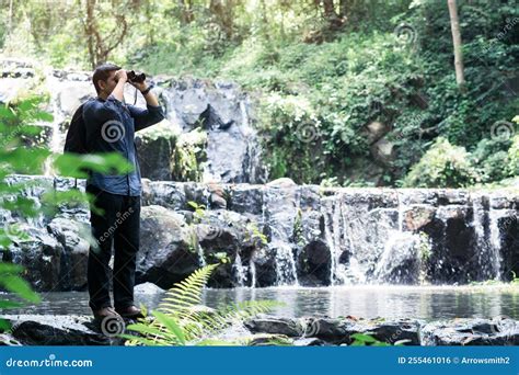 Hiking Tourists With Binoculars Stand At The Waterfall Expedition Concept Traveling Concept