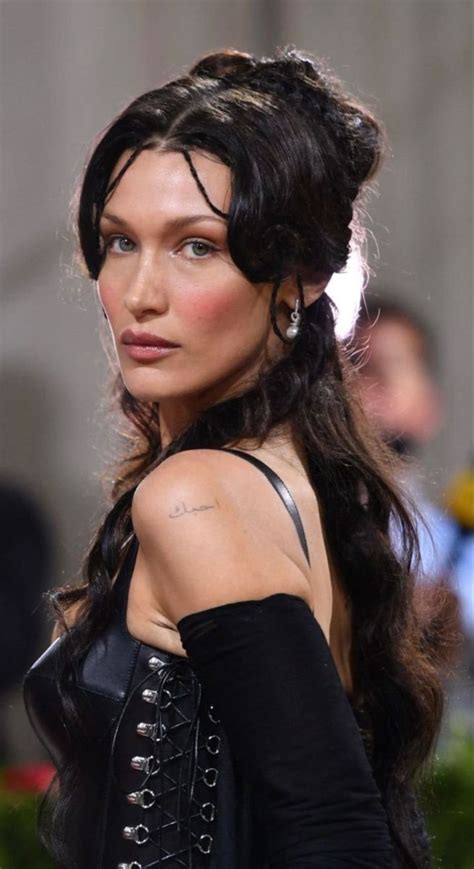 A Woman With Long Black Hair And Tattoos On Her Arm Wearing A Black Dress