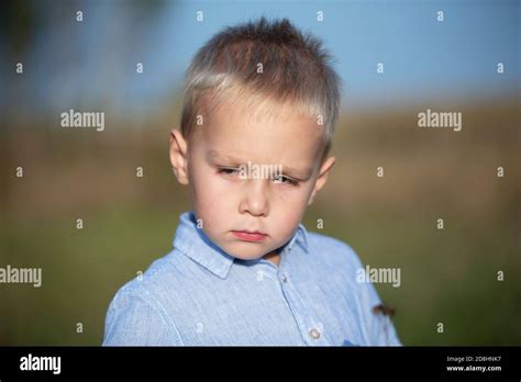 Sad Little Boy With Blond Hair In A Blue Shirt Stock Photo Alamy