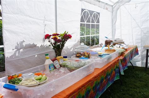 A Table Covered With Food And Drinks Under A White Tent