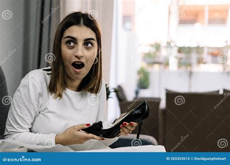 Young Woman On The Sofa At Home With A Surprised Face From Her New Heels Stock Image Image Of