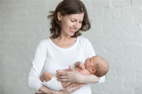 Mujer Con Su Bebé En Brazos Foto Gratis