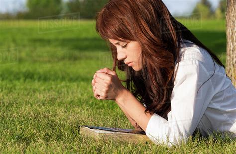 Young Woman Praying With Her Bible In A Park Edmonton Alberta Canada