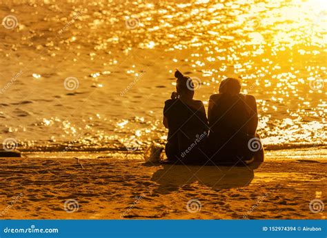 Couple Love Sit Relaxing On The Tropical Beach During Sunset Time Stock