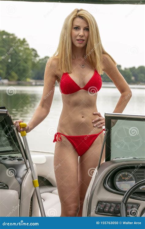 Beautiful Bikini Model Relaxing On A Boat By The Docks Stock Photo