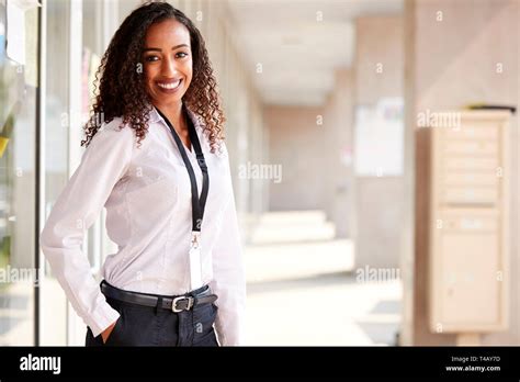 Portrait Of Smiling Female School Teacher Standing In Corridor Of