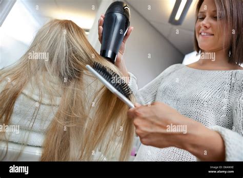 Hairdresser Blow Drying Hair Of Female Stock Photo Alamy