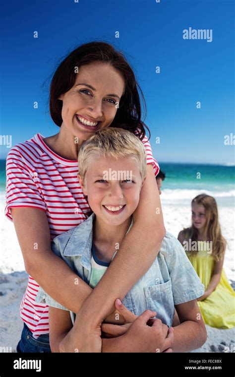 Mother And Son Hugging While Father And Daughter Talking Stock Photo