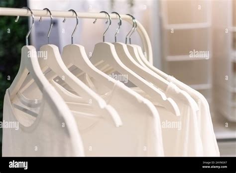 Row Of White T Shirts Hang On White Hangers On A Rack Modern Wardrobe