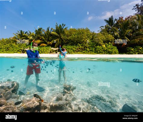 Split Underwater Photo Of Kids Having Fun In Ocean Enjoying Snorkeling