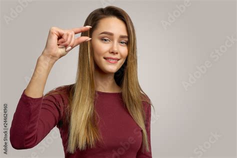 Photo Of Attractive Young Female Shows Something Very Little Or Tiny