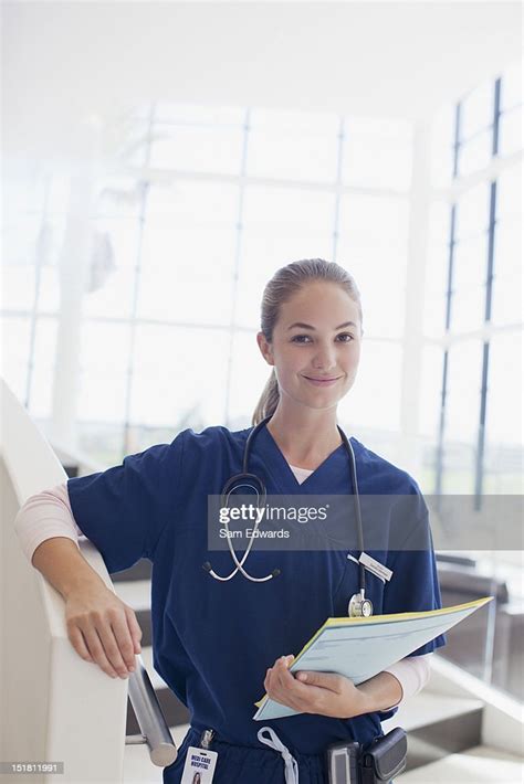 Portrait Of Confident Nurse Holding Medical Record In Hospital High Res