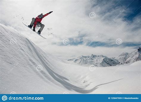 Guy Is Jumping On A Snowboard Against A Blue Sky And Snow