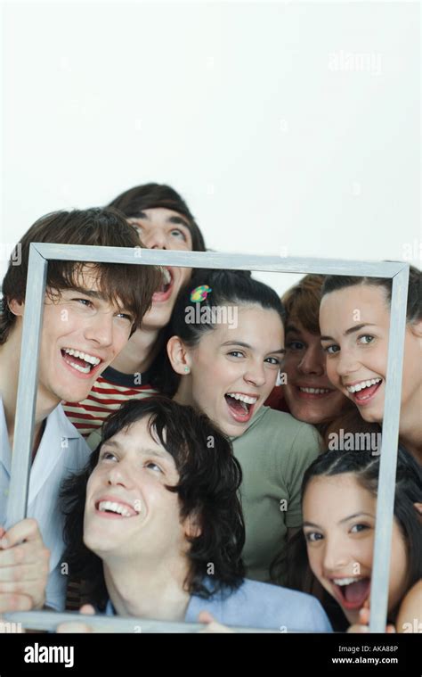 Group Of Young Friends Posing For Photo Holding Up Picture Frame