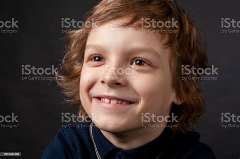 Studio Portrait Of 7 Year Old Boy With Long Brown Hair Stock Photo