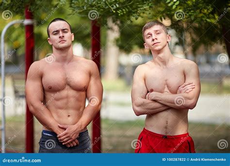 Deux Hommes Musculaires Se Tiennent Sur Un Au Sol De Sports Urbain