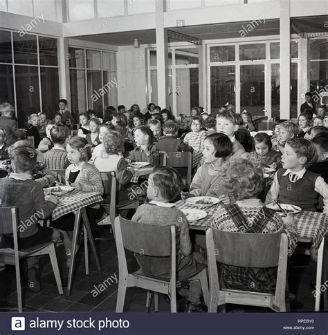 1950s Historical Primary School Children Sitting Together At Wooden