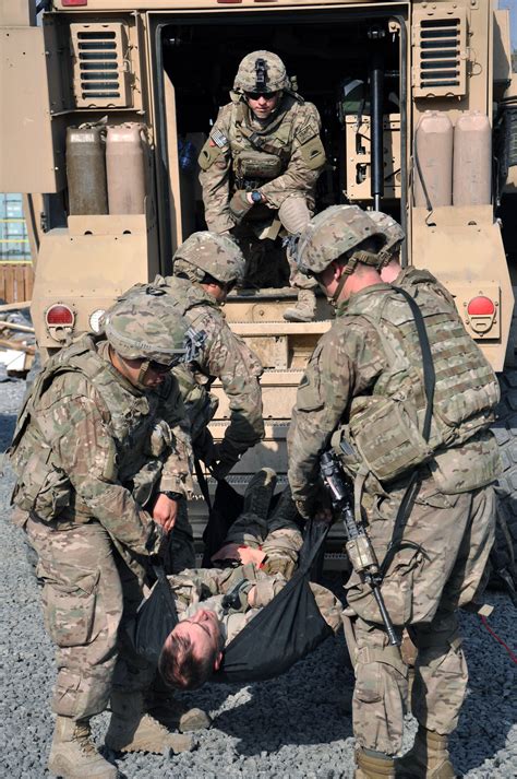 U S Soldiers Practice Lifting An Injured Soldier Into The Back Of A Tactical Vehicle During A
