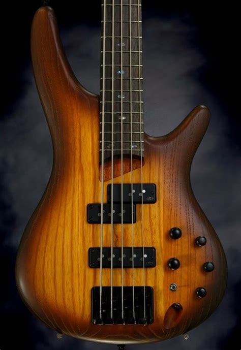 An Electric Bass Guitar Is Shown Against A Black Background