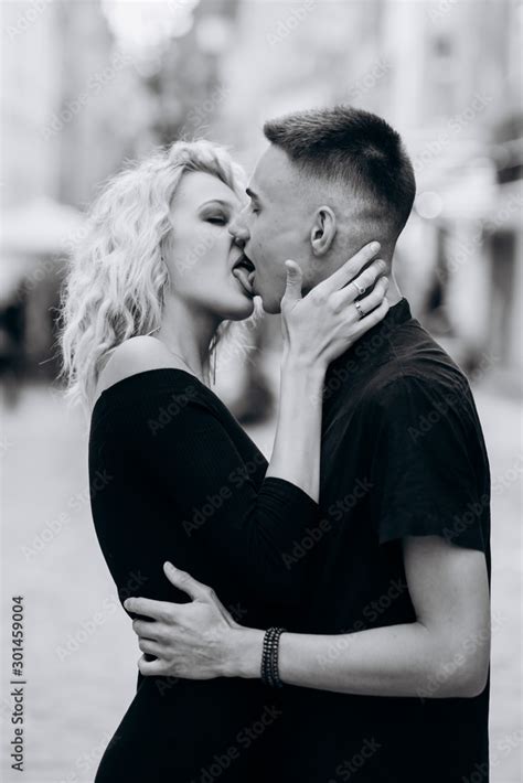 Black And White Portrait Of Loving Couple Kissing On The Street Hot French Kiss Stock Photo