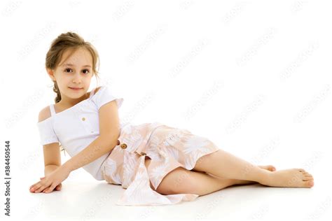Beautiful Preteen Girl Lying On The Floor Against White Background