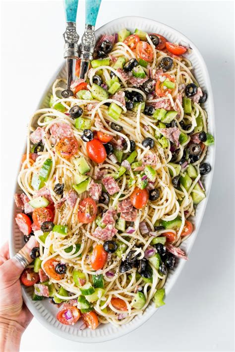 Spaghetti, pepperoni, mushrooms, tomatoes, green olives and parmesan cheese is tossed in an italian salad dressing. Summer Italian Spaghetti Salad Recipe - Reluctant Entertainer