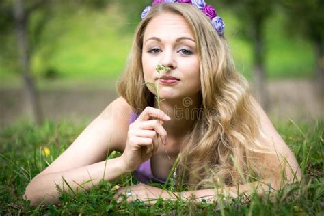 Beautiful Blonde Girl Lying On The Grass And Looking Thoughtfully To