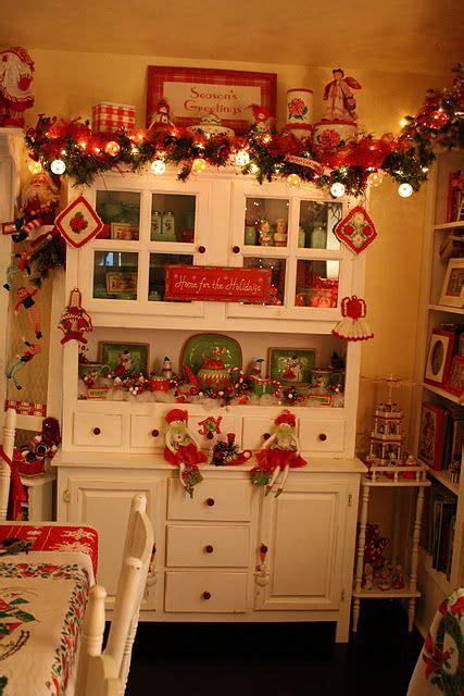 Christmas outdoor vintage decorations for kitchen. Beautiful white hutch decorated for Christmas; red and ...