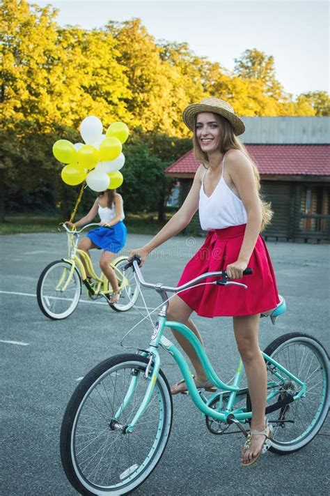 giovane femmina alla moda su una bicicletta in parco ragazza che gode di un giorno sulla bici