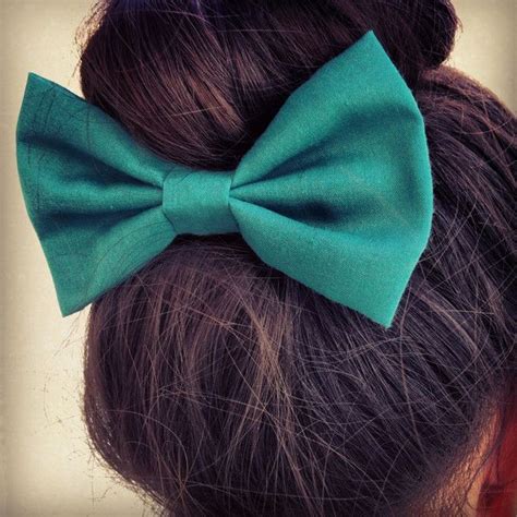 A Close Up Of A Womans Hair With A Green Bow On Her Head