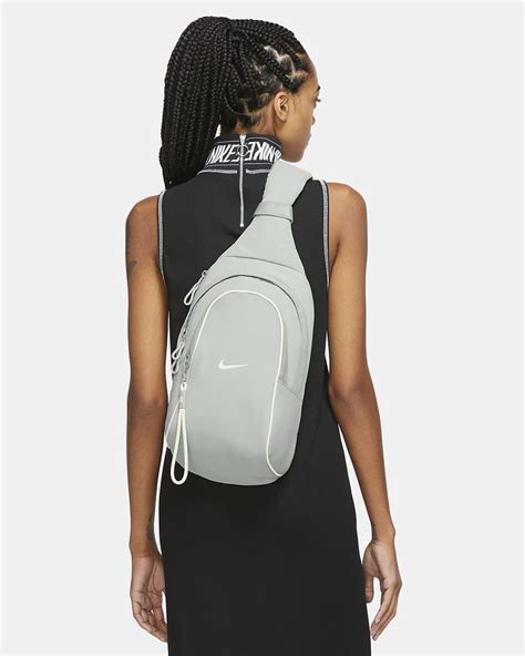 A Woman In A Black Dress With A White Nike Backpack On Her Back Facing