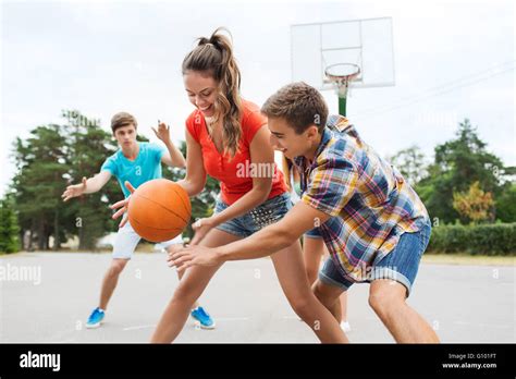 Group Of Happy Teenagers Playing Basketball Stock Photo Alamy